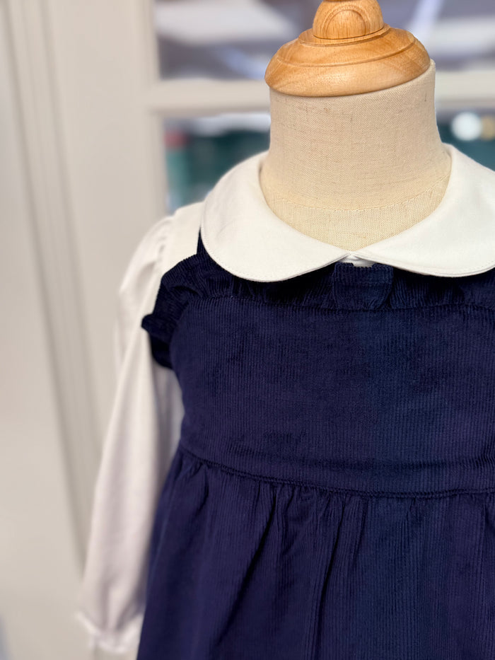 The Macy Drew Dress in Nantucket Navy Corduroy by The Beaufort Bonnet Company wraps your toddler in cozy elegance, perfectly layering over the Maude Peter Pan Collar White Shirt. Ideal for autumn and holiday moments, it invites warmth and timeless charm, with a monogram option for a personalized touch.