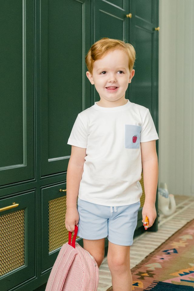 Dress your little boy in the charming Apple Pocket Shirt Short Set by The Proper Peony. The soft white Pima cotton shirt, featuring an adorable apple pocket, pairs perfectly with light blue shorts. It's not just stylish—it's incredibly comfortable, making it ideal for school days or playful adventures!