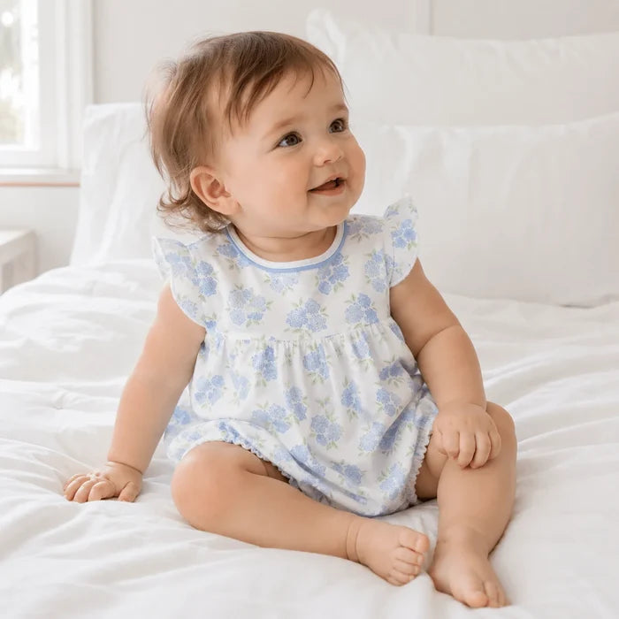 Light, playful, and effortlessly sweet, the Magnolia Baby Dreamy Hydrangeas Print Flutter Bubble in sky blue is a charming outfit for your little girl. Crafted from luxuriously soft 100% Pima cotton, this baby bubble offers breathable comfort while remaining gentle on delicate skin.