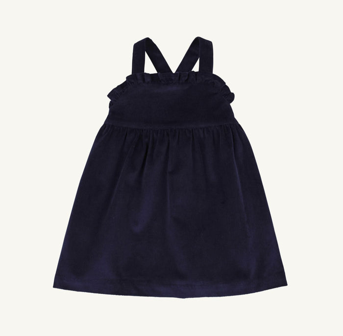 The Macy Drew Dress in Nantucket Navy Corduroy by The Beaufort Bonnet Company wraps your toddler in cozy elegance, perfectly layering over the Maude Peter Pan Collar White Shirt. Ideal for autumn and holiday moments, it invites warmth and timeless charm, with a monogram option for a personalized touch.