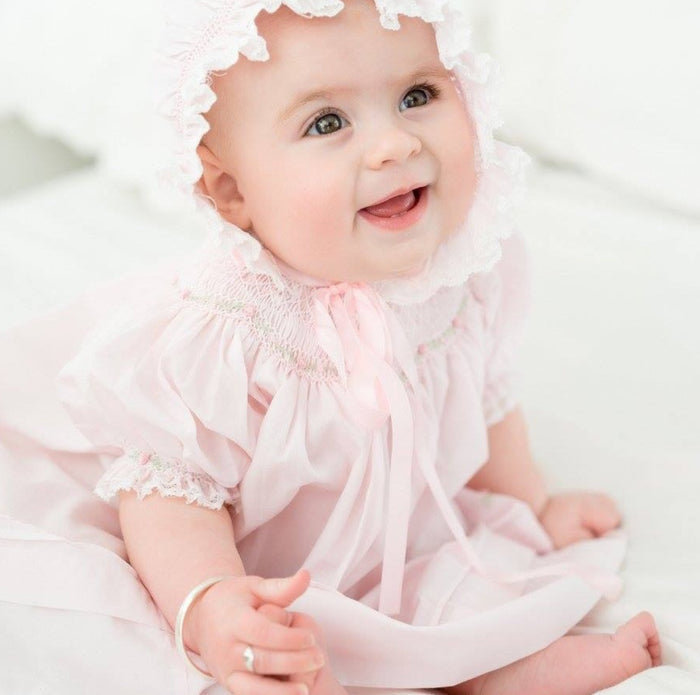 Experience the enchanting charm of the Rosette Bishop Dress by Feltman Brothers. This timeless pink dress, exudes elegance with its classic smocking and delicate ruffle sleeves. Perfect for creating cherished memories, it’s an heirloom piece that celebrates the beauty of childhood!